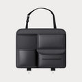 Black leather car seat back storage hanging bag with carrying handle shown attached to vehicle seat