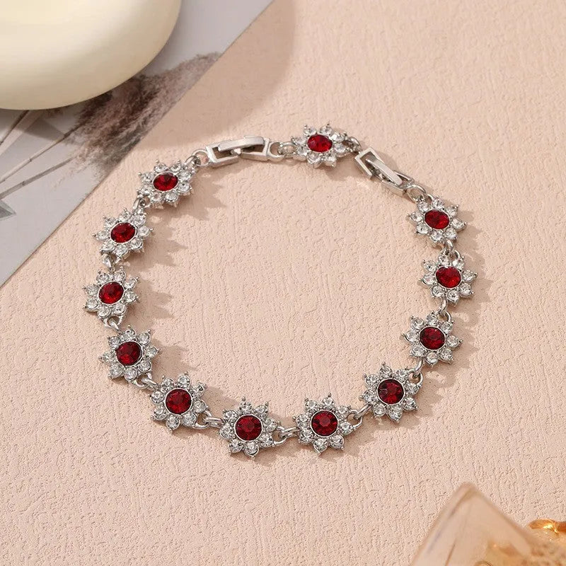 Gold and silver flower bracelet with colourful crystal and simulated diamond stones on a wrist.