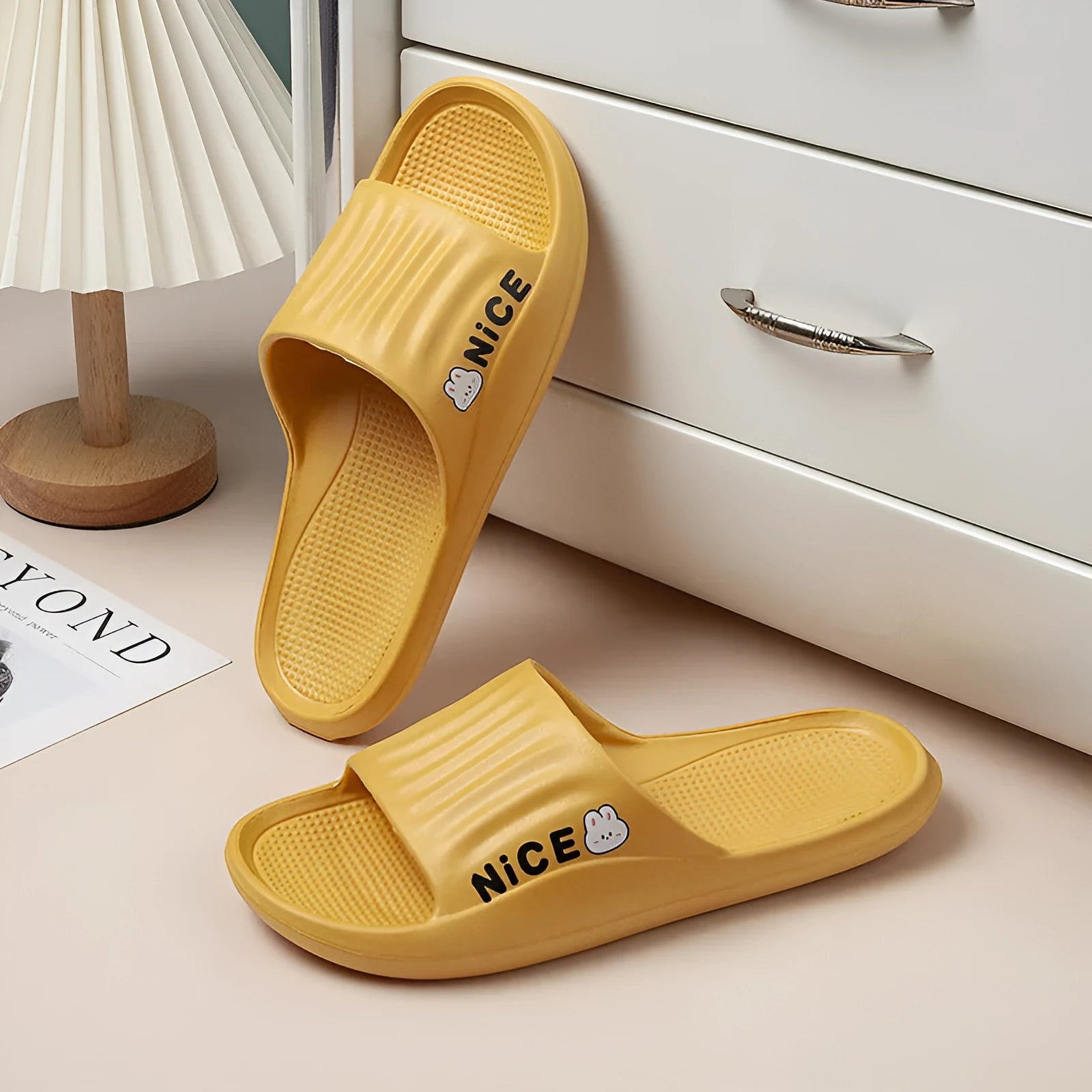 Pair of lightweight EVA flip-flop slippers with a minimalist cartoon pattern and non-slip soles.