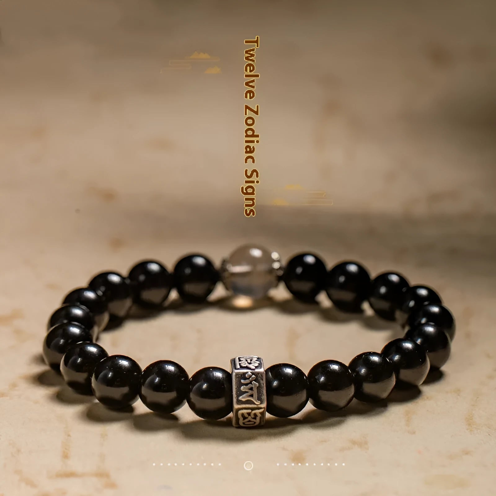 Old Pit Obsidian 8mm bead bracelet with zodiac animal charms on a wrist, showing ethnic style and unset inlaid design.
