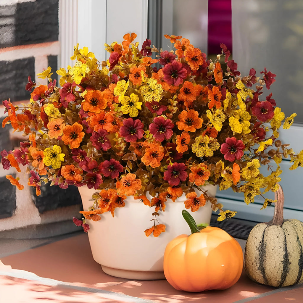 Plastic and silk artificial flower bouquet in autumn red, yellow, orange, and orange-yellow colours for home and event decor.