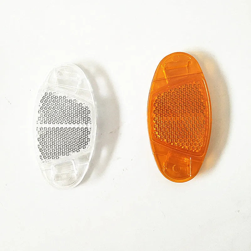 Yellow and white plastic bicycle spoke reflectors showing size of 7.2cm by 3.5cm.