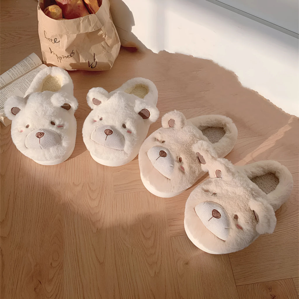 A pair of milky white baotou slippers with suede uppers and a cartoon pattern, showing the round toe shape.