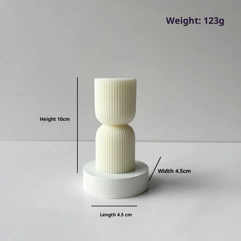 White cylindrical soy wax aromatherapy candle with geometric spherical shape on a table