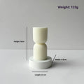 White cylindrical soy wax aromatherapy candle with geometric spherical shape on a table