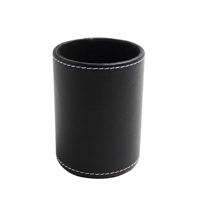 Small round black leather pen container on a desk