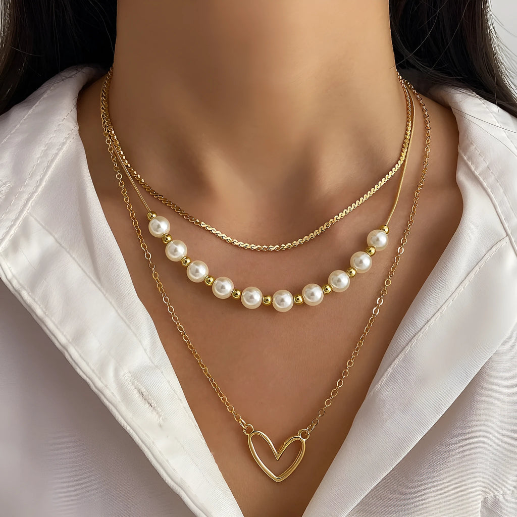 Vintage gold necklace with heart-shaped pendant on adjustable pearl-style chain