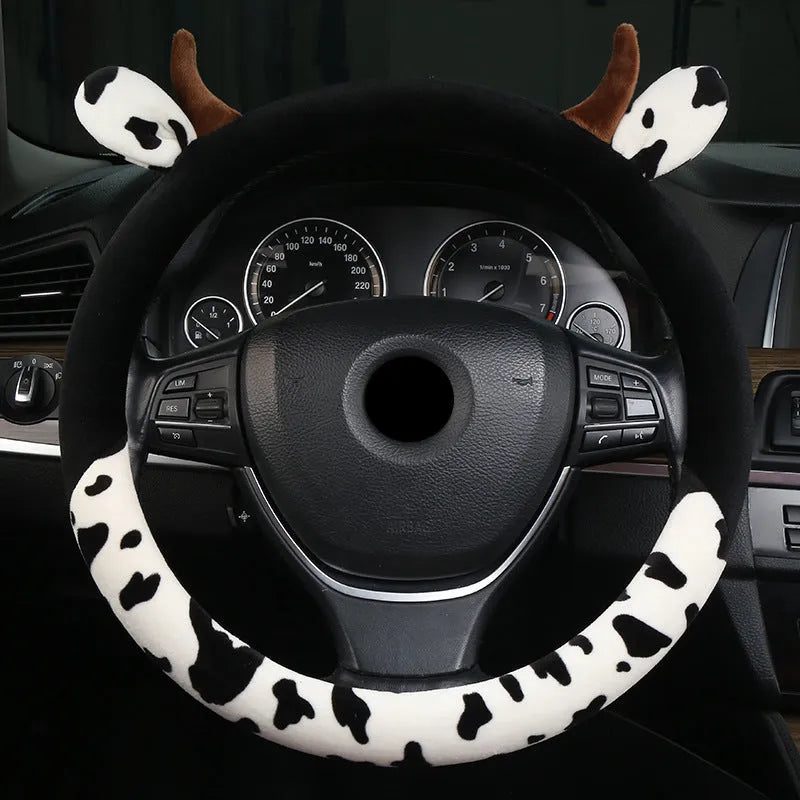 Short plush automotive steering wheel cover in black, showing protective handle detail.