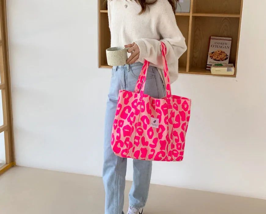 Women's large canvas shoulder bag in Oxford cloth with a three-dimensional front pocket, shown in various colours.