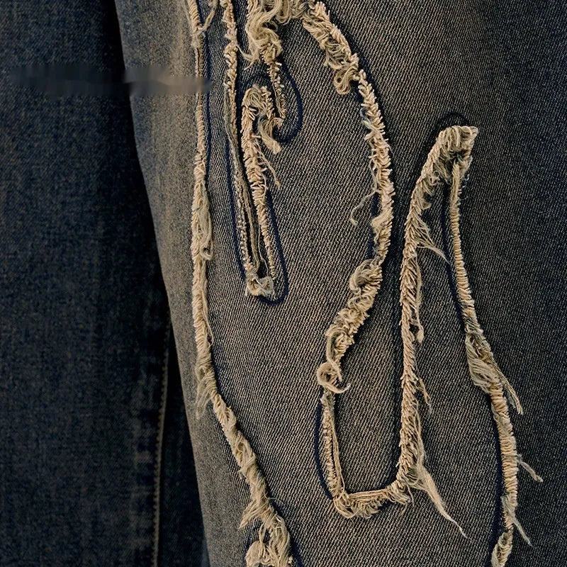 Men's black cropped denim shorts with a flame embroidery patch on the leg, showing straight cut.