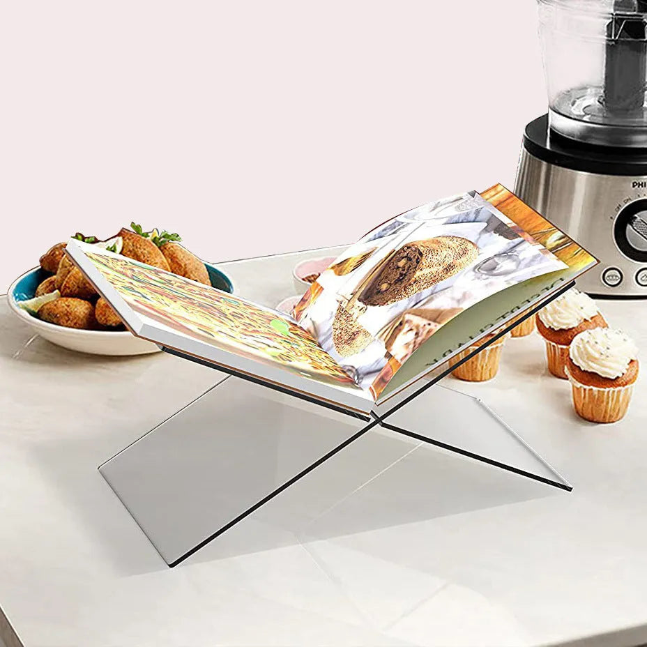 Clear acrylic X-shaped desktop book display rack holding a book.