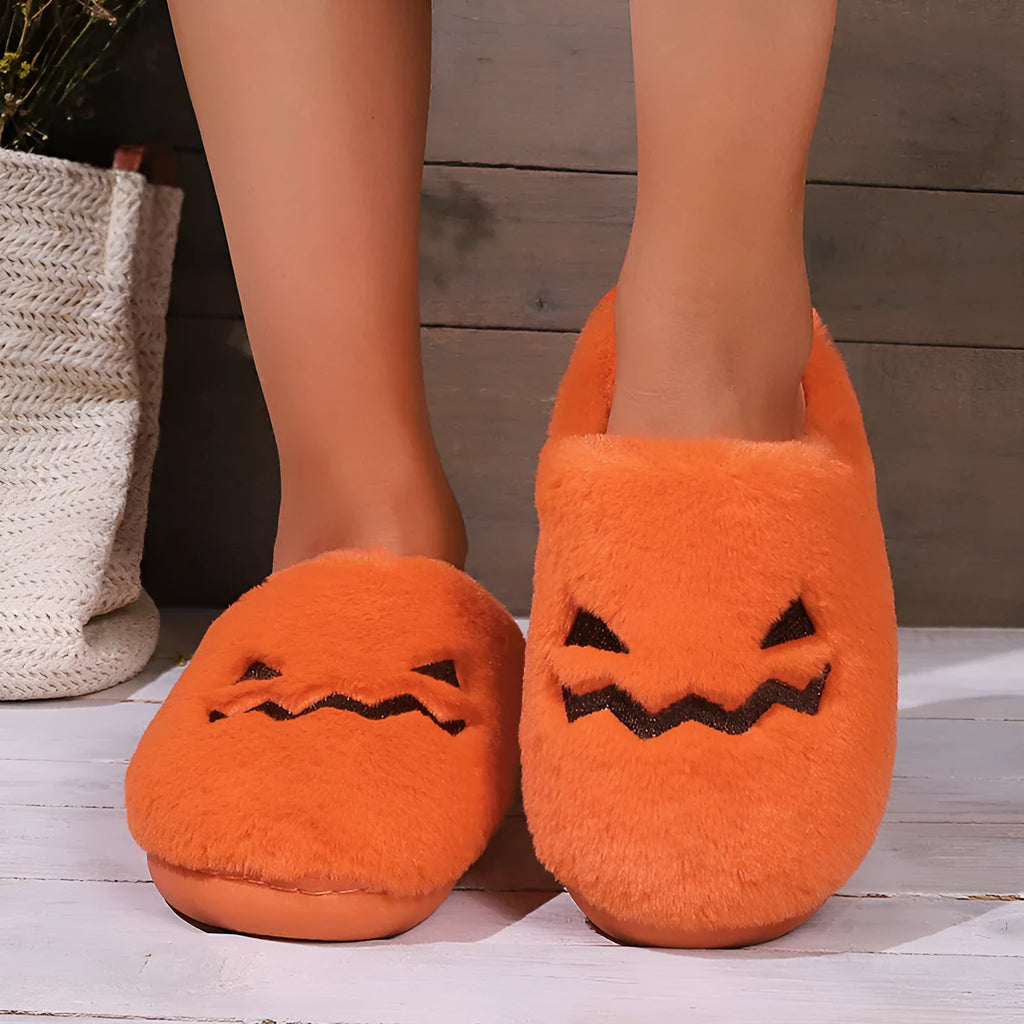 Orange Halloween pumpkin slippers with coral velvet upper and plush lining on a non-slip PVC sole.