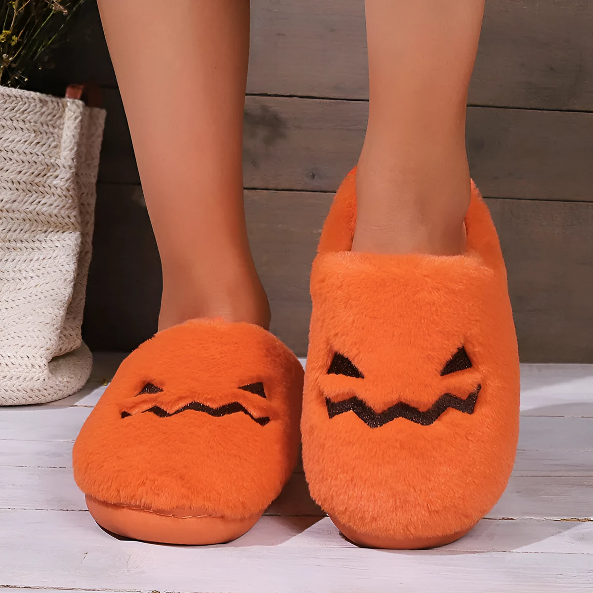 Orange Halloween pumpkin slippers with coral velvet upper and plush lining on a non-slip PVC sole.