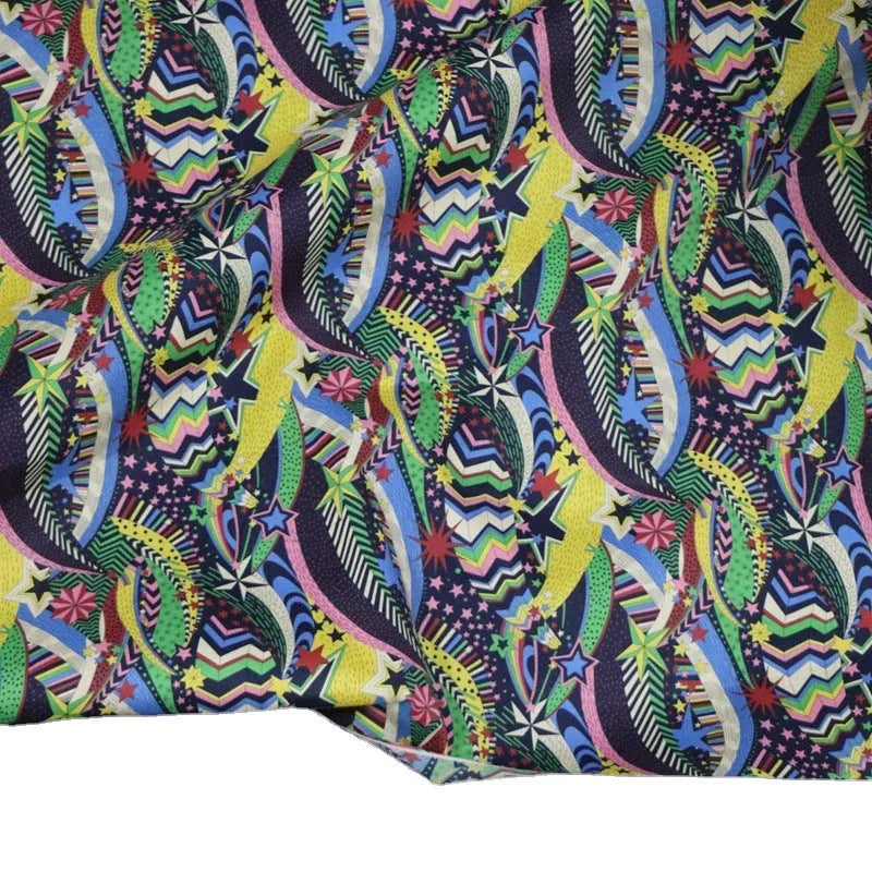 Blue floral printed cotton fabric on a roll showing plant and flower design, 145cm wide.