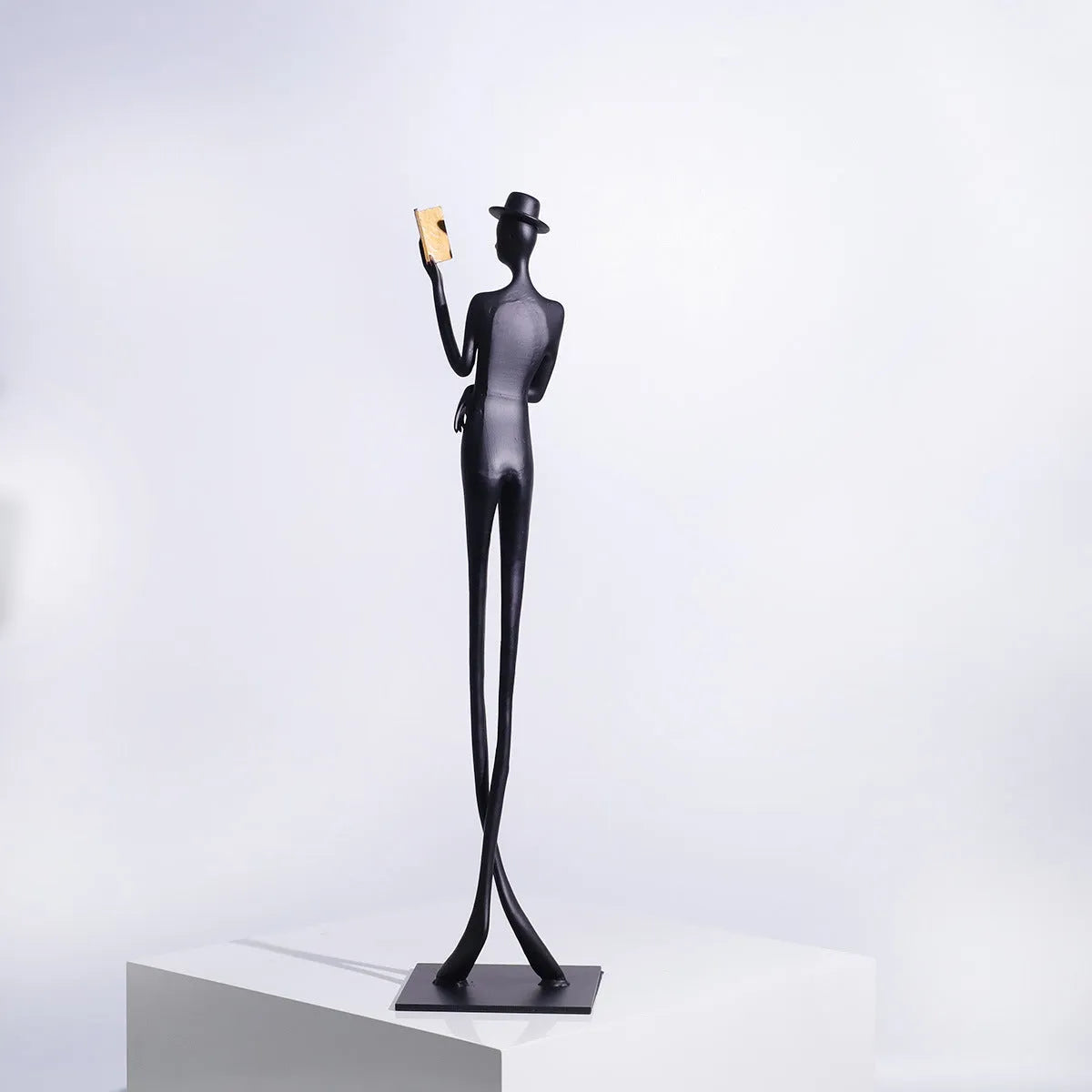 Black metal cast aluminium reading woman sculpture on desk, modern minimalist style