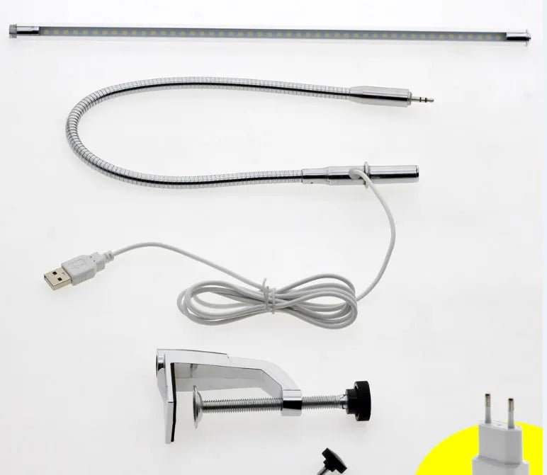 Silver LED clip-on table lamp with long arm extended, showing aluminium alloy construction and USB cable.