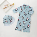Boy's penguin print long sleeve swimsuit with matching swimming cap set on white background