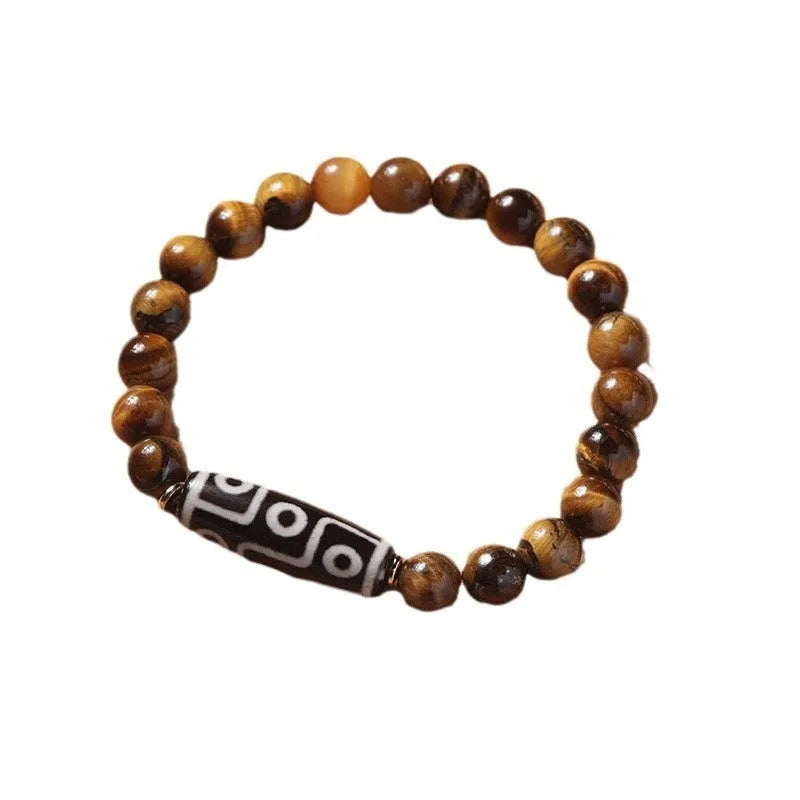 Ethnic style single circle bracelet with a patterned Tigereye Dzi bead on wrist.