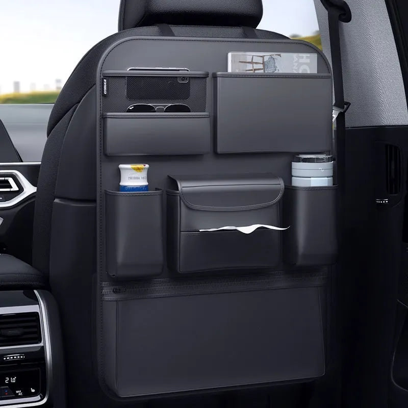 Black leather car seat back storage hanging bag with carrying handle shown attached to vehicle seat