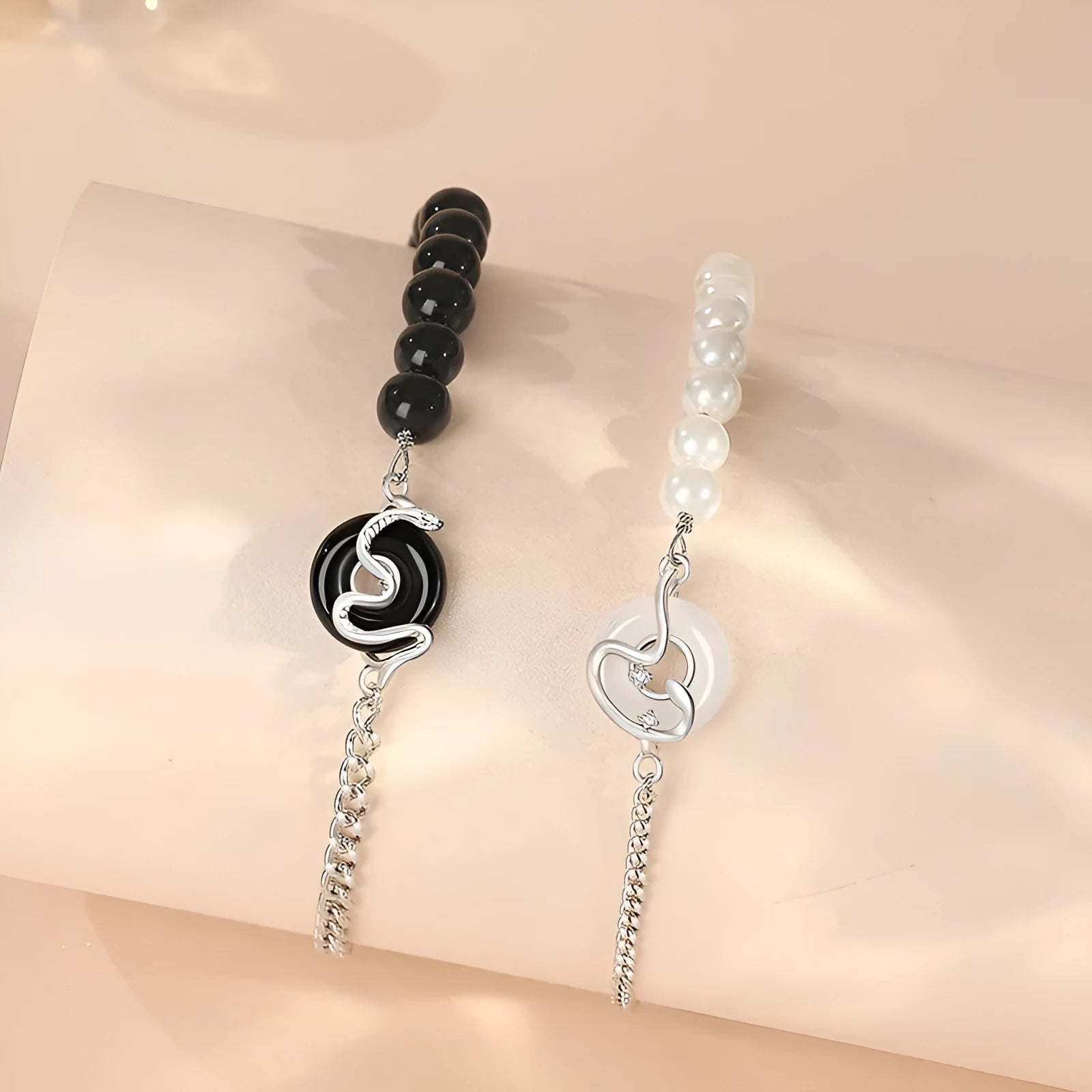 Close-up of a 925 sterling silver bracelet with a safe buckle, featuring obsidian pearls and a detailed snake charm in a new Chinese style.