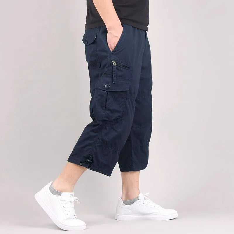 Men's cropped casual trousers in loose fit cotton fabric, shown in khaki colour with sports wear application