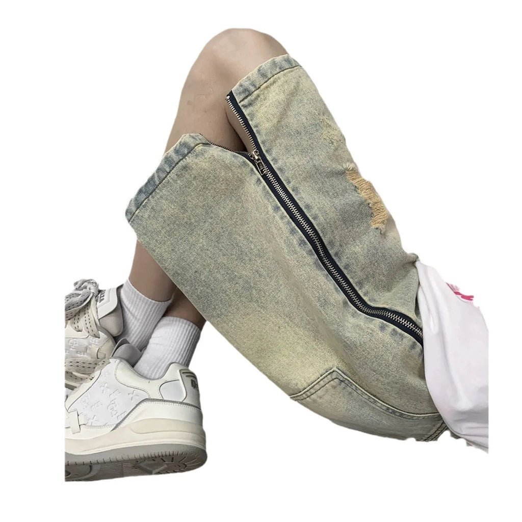 Men's blue denim shorts with mud-wash finish and ripped distressing on a hanger