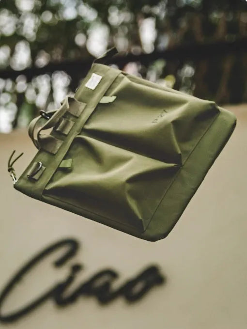 Canvas messenger bag in charcoal black with shoulder strap showing laptop compartment