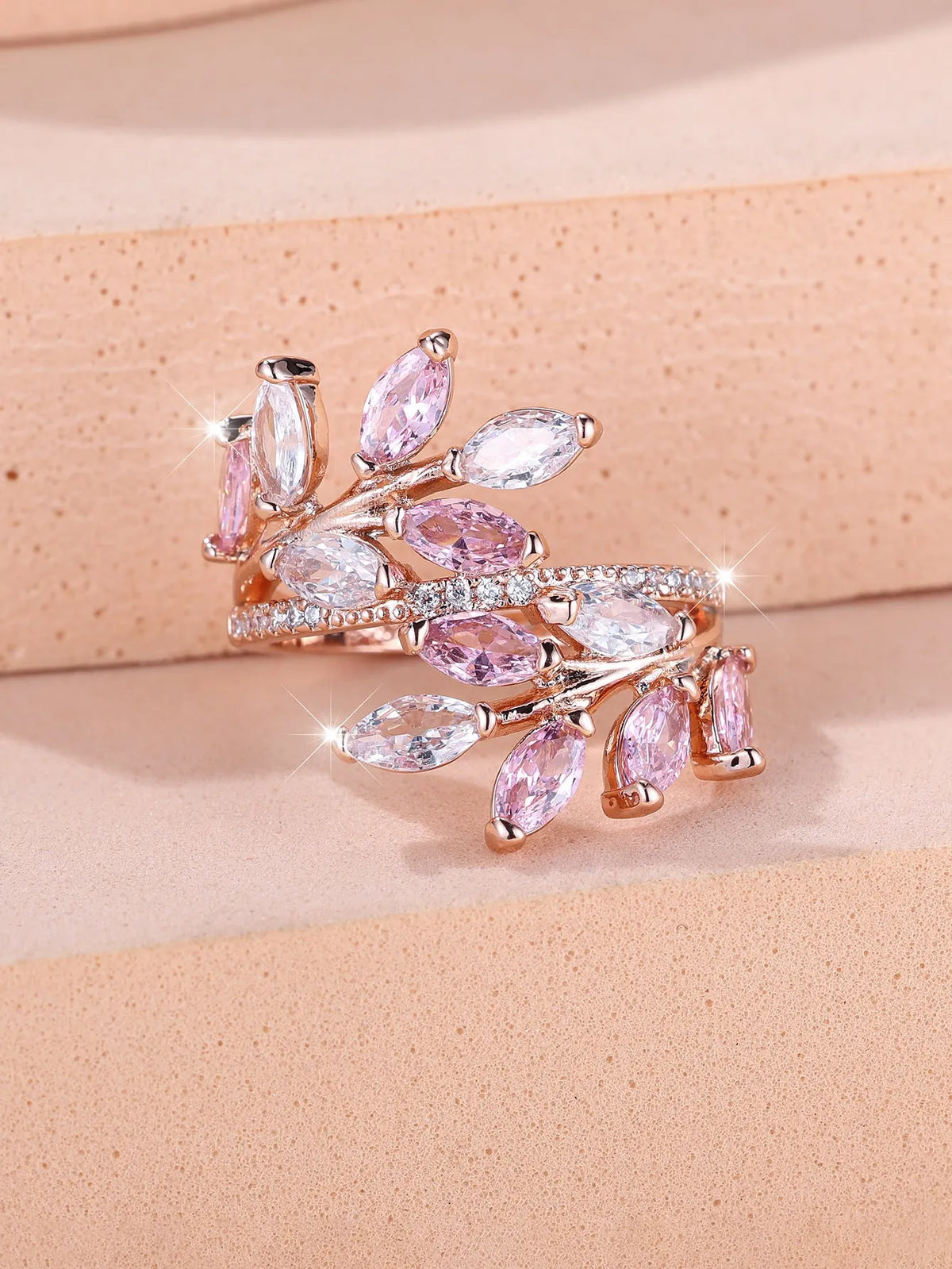 Adjustable copper leaf ring in platinum or rose gold finish on a white background