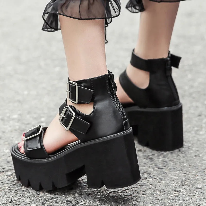 Black women's punk-style Roman sandals with a chunky platform heel and a back zipper closure.