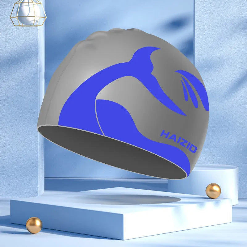 Adult unisex silicone swim cap with whale tail pattern and built-in ear protectors in four colours.