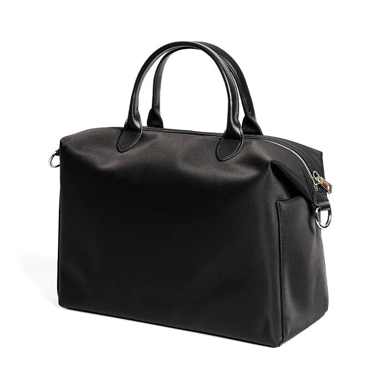 Black nylon waterproof shoulder bag with leather handles showing large open interior.