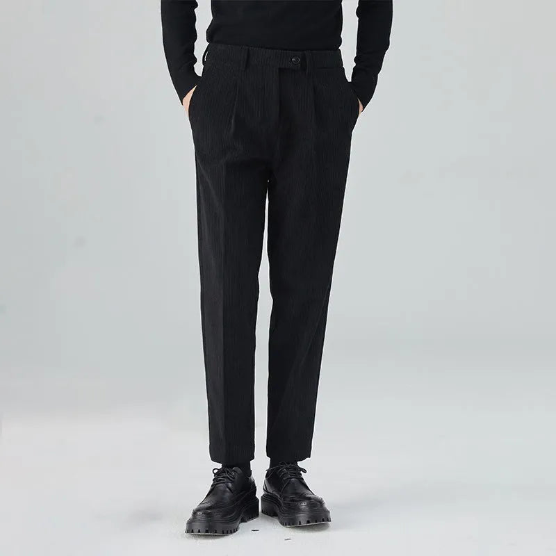 Men's straight-leg corduroy trousers in beige, shown laid flat to display the mid-waist and textured fabric.