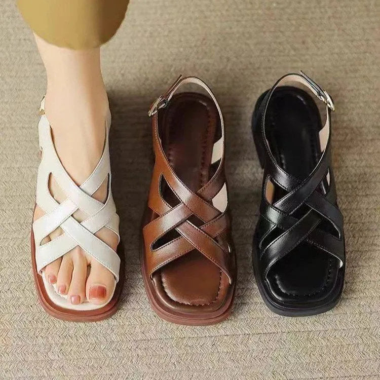 Women's glossy patent leather square toe sandals with winding tape fastening on a neutral background.