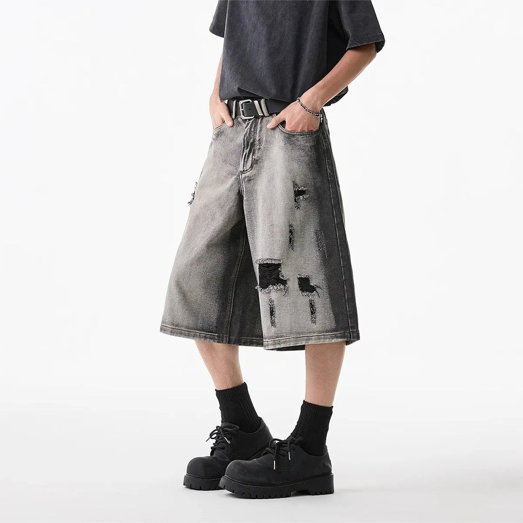 Grey denim shorts with loose fit and cropped length on hanger