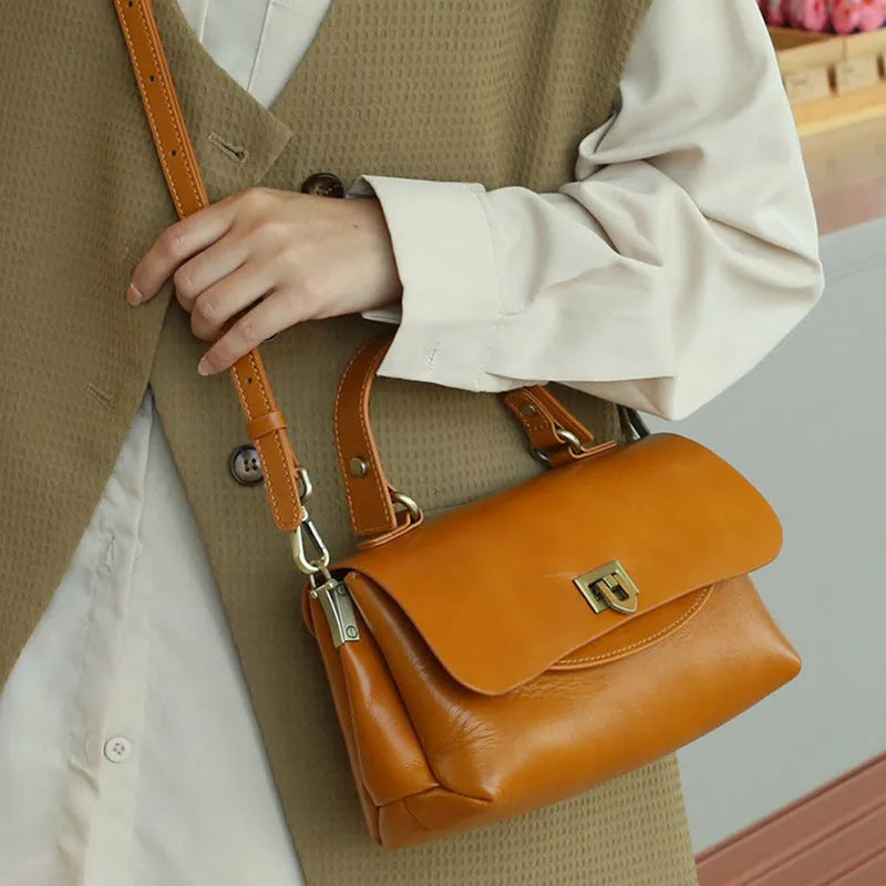 Women's brown leather saddleback handbag with double straps and multiple compartments