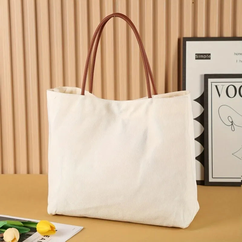 Beige white canvas tote bag with reinforced cotton handles and a flat base.