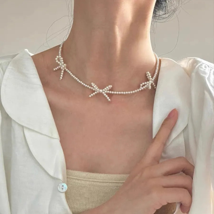 White imitation pearl necklace with bow pendant on adjustable 31-40cm chain